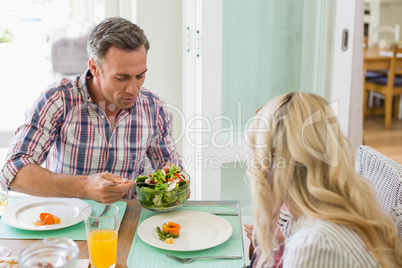 Man serving food to woman on dinning table