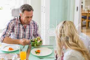 Man serving food to woman on dinning table