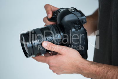 Mid section of male photographer standing in studio