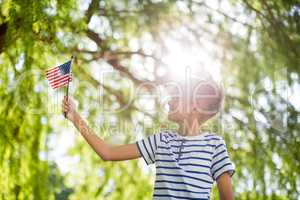 Boy holding small american flag in park
