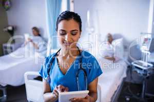 Beautiful female doctor using digital tablet in the ward