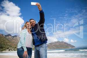 Mature couple sticking out tongue while taking selfie