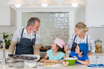 Parents and kids preparing food in kitchen