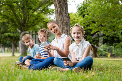 Kids using mobile phone in park