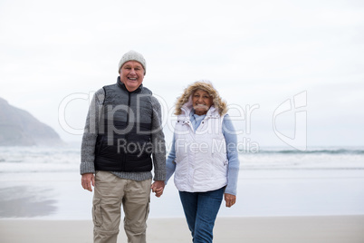 Senior couple walking with holding hands on the beach