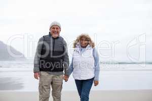 Senior couple walking with holding hands on the beach