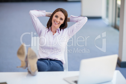 Happy businesswoman relaxing at desk