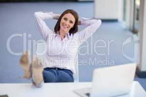 Happy businesswoman relaxing at desk