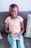 Girl listening to music from digital tablet