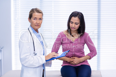 Patient suffering from stomach ache while consulting doctor