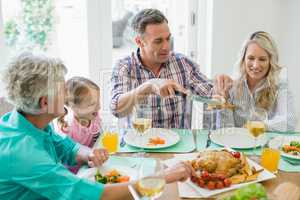 Multi- generation family having meal on dinning table