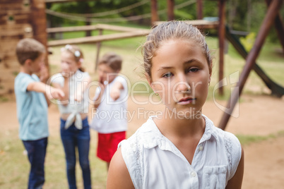 Upset girl with friends gossiping in background