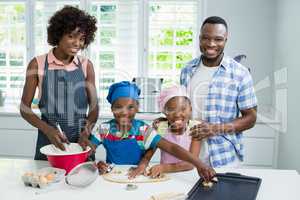 Parents and kids preparing food in kitchen at home