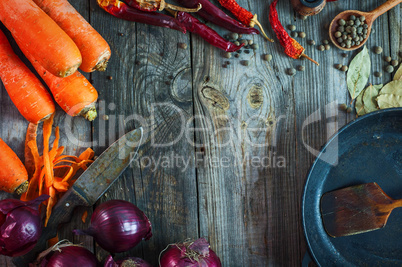 Fresh carrots and red onion with a frying pan