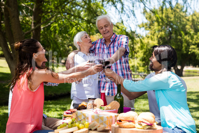 Happy family having red wine in park