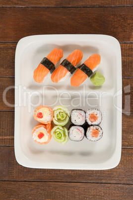 Uramaki and nigiri sushi served in white plate