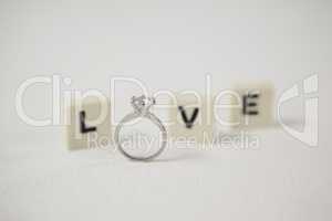 Diamond ring between white blocks displaying love message