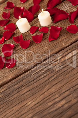 Wax candles surrounded with rose petals