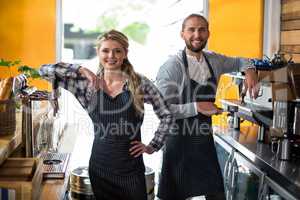 Portrait of smiling waitress and waiter working at counter