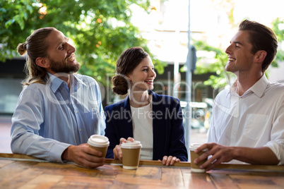 Young friends interacting with each other while having coffee