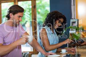 Woman entering pin code on credit card reader at counter