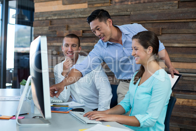 Businesspeople interacting while working on personal computer