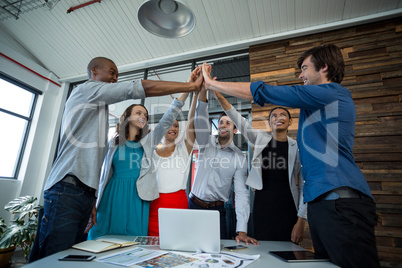 Team of graphic designers giving high five to each other