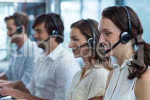 Business executives with headsets using in office