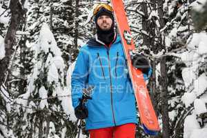 Skier walking with ski on snow covered mountains