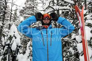 Skier adjusting his sunglasses