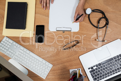 Businesswoman writing on clipboard