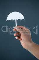 Hand of businessman holding paper cut out umbrella