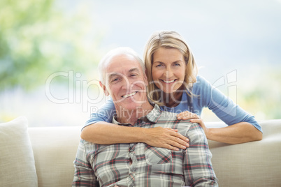 Portrait of senior woman embracing a man in living room