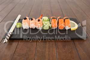 Nigiri sushi served with chopsticks in black stone slate