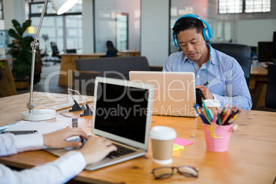 Business executives using laptop at desk