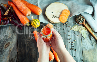 Jar of fresh carrot juice in female hand