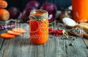 Fresh carrot juice in a glass jar