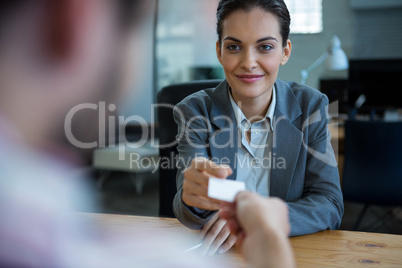 Business executive giving visiting card to man during interview