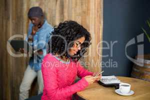Woman using mobile phone while having a coffee in cafÃ?Â©