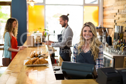 Smiling waitress and waiter working at counter