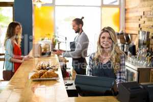 Smiling waitress and waiter working at counter