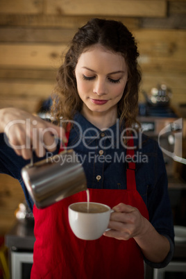 Smiling waitress making cup of coffee Smiling waitress making cup of coffee
