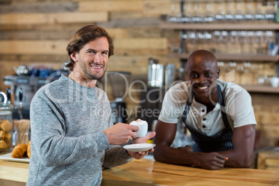 Portrait of male customer smiling while having coffee