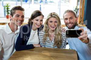Happy friends taking selfie from mobile phone