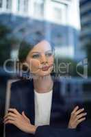 Thoughtful businesswoman sitting with arms crossed