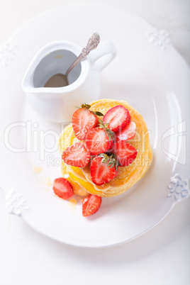 Stack of sweet pancakes with strawberry and honey.