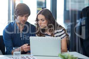 Male and female business executive using mobile phone