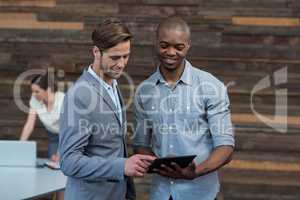 Business executives discussing over digital tablet