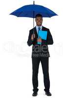 Portrait of businessman holding blue umbrella and a file
