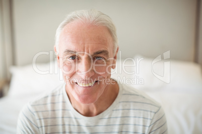 Portrait of smiling man in bedroom